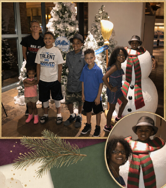 Children celebrating Christmas beside a decorated tree and snowman